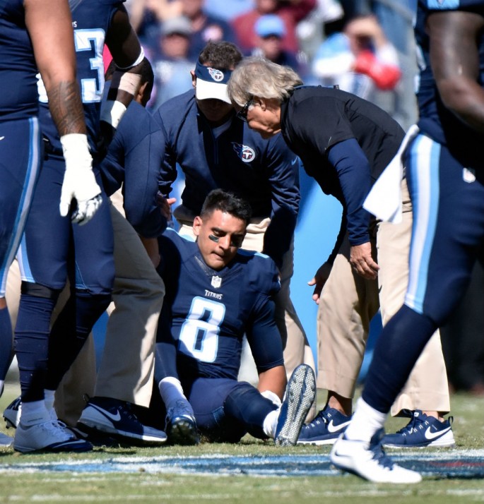 Tennessee Titans quarterback Marcus Mariota (#8) is being attended by medical staff after receiving a late and low hit from the Miami Dolphins.
