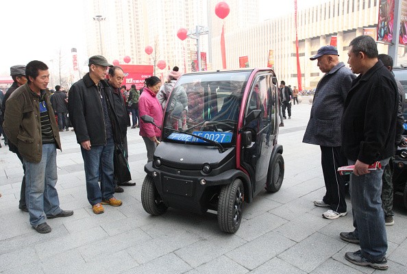 People look at a BIRO City electric vehicle at Wanda Plaza, Yantai, Shandong Province, on Nov. 21, 2014.