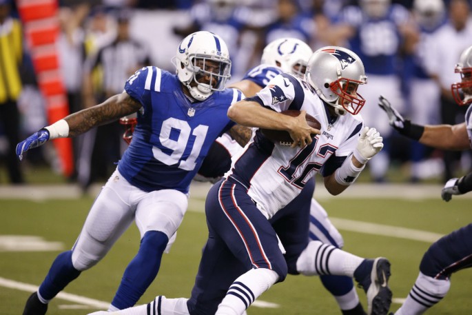 New England Patriots quarterback Tom Brady (#12) runs away from Indianapolis Colts' Jonathan Newsome (#91).