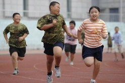 Children exercise during a weight-loss summer camp in China.