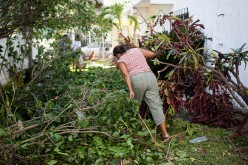 A woman climbs through tree branches in her backyard on October 24, 2015 in Cuastecomates, Mexico. The damage was caused by Hurricane Patricia, which struck Mexico's West coast yesterday afternoon and left minor flooding and damage.