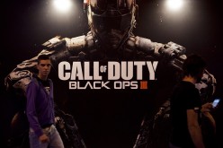 Fairgoers pass by a giant poster of last installment of Call of Duty from US video game publisher Activision and called 'COD: Black Ops III' during the Madrid Games Week