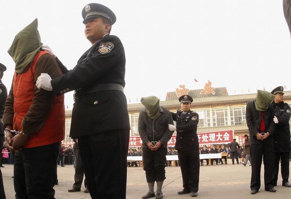 Police parade criminals during a public sentence at the Xian Railway Station in Shaanxi Province, China, in this Jan. 14, 2006 photo. 