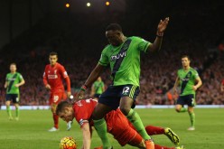 Southampton's Victor Wanyama (standing) competes for the ball against Liverpool's James Milner.