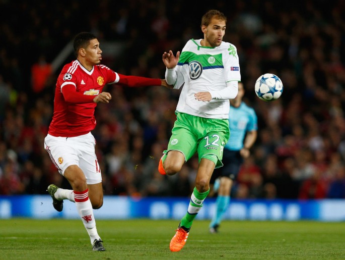 Wolfsburg striker Bas Dost (R) dribbles past Manchester United defender Chris Smalling in a recent Champions League match.