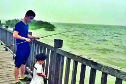 Zhu with daughter Grace trying their luck to catch some fish together.