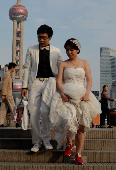 A newlywed couple walk down the stairs after posing for pictures at the Bund in central Shanghai.