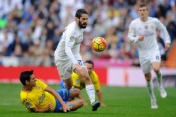 Real Madrid midfielder Isco is tackled by Las Palmas' Vicente Gomez.