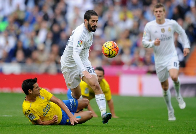 Real Madrid midfielder Isco is tackled by Las Palmas' Vicente Gomez.