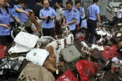 Chinese law enforcers sort out counterfeit bags seized in a crackdown in Shanghai.