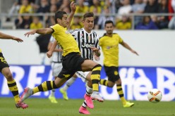 Borussia Dortmund winger Henrikh Mkhitaryan competes for the ball against Juventus' Paulo Dybala.