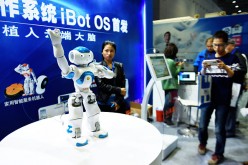 Spectators and organizers look on as a robot operating on China's first robot operating system--iBot OS--performs at the China International Industry Fair.
