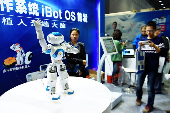 Spectators and organizers look on as a robot operating on China's first robot operating system--iBot OS--performs at the China International Industry Fair.