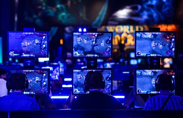 Visitors try out the massively multiplayer online role-playing game 'World Of Warcraft' at the Blizzard Entertainment stand at the Gamescom 2015 