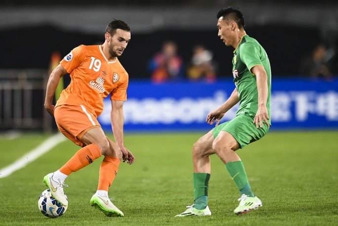 China striker Yu Dabao (R) plays for Chinese club Beijing Guoan against Brisbane Roar's Jack Hingert during an Asian Champions League match.