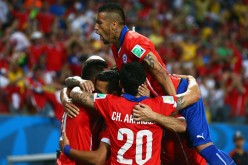 Chile midfielder Arturo Vidal jumps on teammates after Alexis Sánchez's goal.