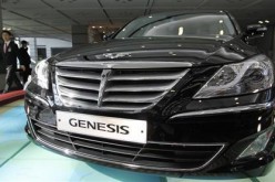 An employee of Hyundai Motor walks past the company's luxury sedan 'Genesis' displayed for visitors after its annual general meeting of stockholders at the automaker's headquarters in Seoul March 11, 2011.