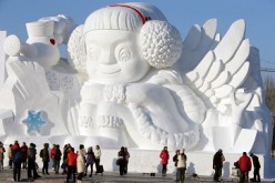 Tourists look at a large snow sculpture at the Sun Island Park during the 26th China Harbin International Snow Sculpture Art Expo in 2013 in Harbin, Heilongjiang Province.