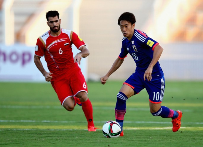 Japan midfielder Shinji Kagawa dribbles past Syria's Zahir Algunam.