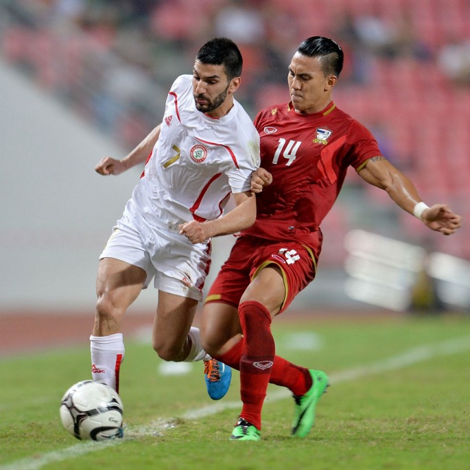 Lebanon striker Hassan Maatouk competes for the ball against Thailand's Teeratep Winotha.