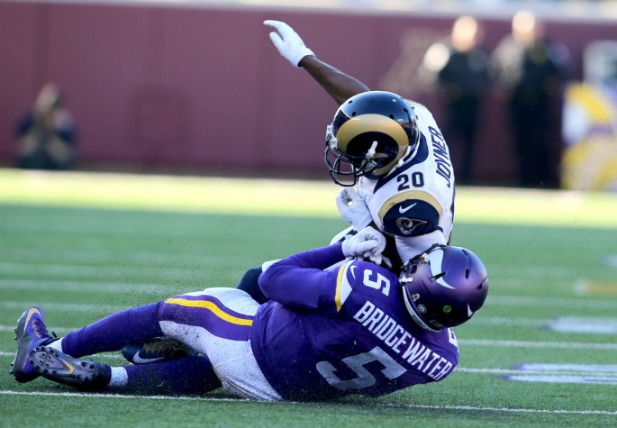 Minnesota Vikings quarterback Teddy Bridgewater (#5) was knocked down by St. Louis Rams' Lamarcus Joyner (#20).