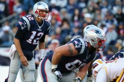 New England Patriots quarterback Tom Brady (#12) calls a play in the line of scrimmage against the Washington Redskins.