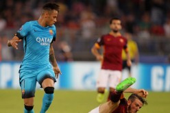 Barcelona winger Neymar (L) looks down at a fallen Alessandro Florenzi of Roma.