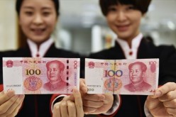 Two employees of China Citic Bank's Hangzhou branch on Thursday present a new version of the 100-yuan bank note (left) alongside the current one.