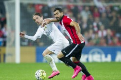 Athletic Bilbao's Mikel Balenziaga competes for the ball against Real Madrid's Luka Modric.