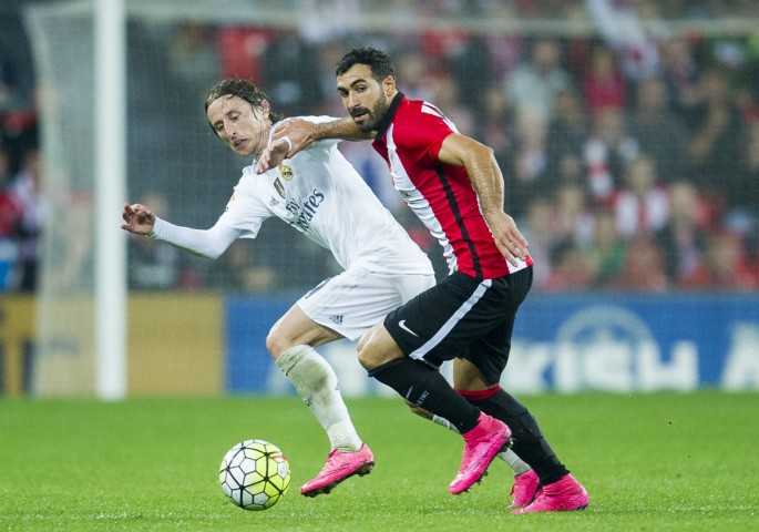 Athletic Bilbao's Mikel Balenziaga competes for the ball against Real Madrid's Luka Modric.
