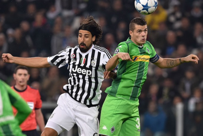 Borussia Monchengladbach midfielder Granit Xhaka competes for the ball against Juventus' Sami Khedira.