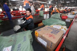 Workers sort the packages in an express company in Nantong, Jiangsu Province, on Nov. 10, 2015. 