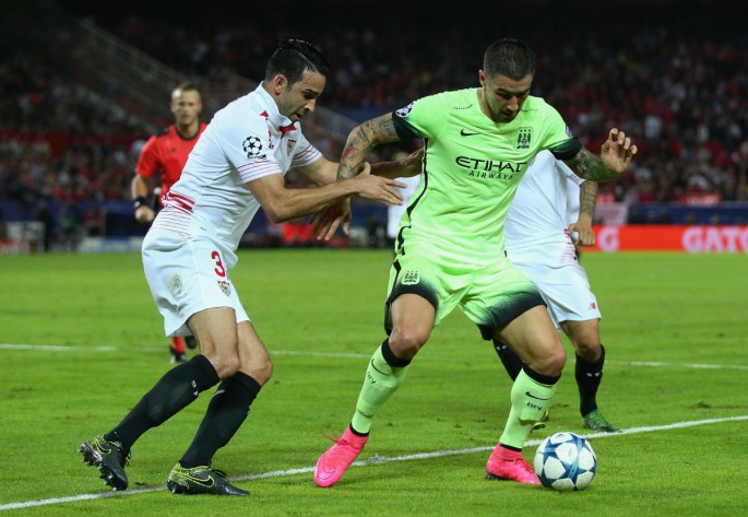 Sevilla defender Adil Rami (L) competes for the ball against Manchester City's Aleksandar Kolarov.