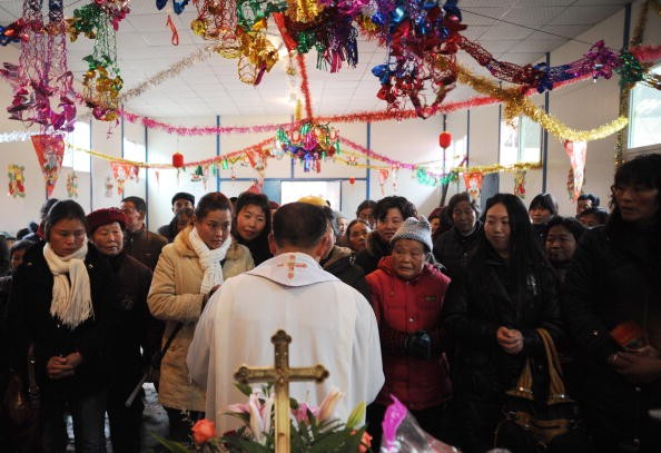  A priest baptizes a villager during a Christmas Day mass at the Church of Xiushui Township in Anxian, Sichuan Province, on Dec. 25, 2008.
