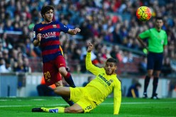 Villarreal's Jonathan dos Santos (in yellow) competes for the ball against Barcelona's Sergio Roberto.