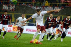 AS Roma striker Edin Dzeko (middle) scores his team's second goal against Bologna from the penalty area.