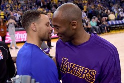 Stephen Curry of the Golden State Warriors meets at center court with Kobe Bryant of the Los Angeles Laker prior to the start of their NBA basketball game at ORACLE Arena on November 24, 2015 in Oakla
