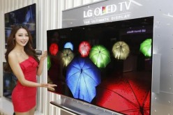 A model poses next to LG Electronics' organic light-emitting diode (OLED) television in Seoul.  