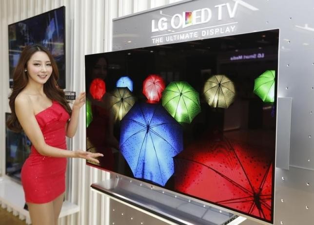 A model poses next to LG Electronics' organic light-emitting diode (OLED) television in Seoul.  
