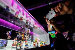 An attendee takes photographs of Super Smash Bros. model characters from Nintendo Co.'s Amiibo game displayed during the E3 Electronic Entertainment Expo in Los Angeles, California, U.S., on Tuesday, June 16, 2015.