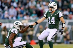 New York Jets quarterback Ryan Fitzpatrick (#14) helps up wide receiver teammate Brandon Marshall after a play against the Miami Dolphins.
