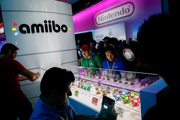 An attendee takes photographs of Super Smash Bros. model characters from Nintendo Co.'s Amiibo game displayed during the E3 Electronic Entertainment Expo in Los Angeles, California, U.S., on Tuesday, June 16, 2015. 