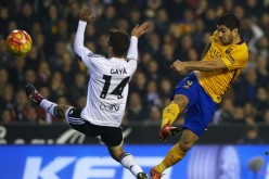 Barcelona striker Luis Suárez shoots off Valencia's Jose Gaya.