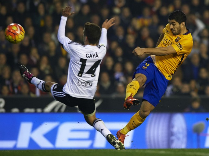 Barcelona striker Luis Suárez shoots off Valencia's Jose Gaya.