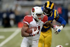 Arizona Cardinals running back David Johnson (#31) carries the ball while under pressure from St. Louis Rams' Aaron Donald.