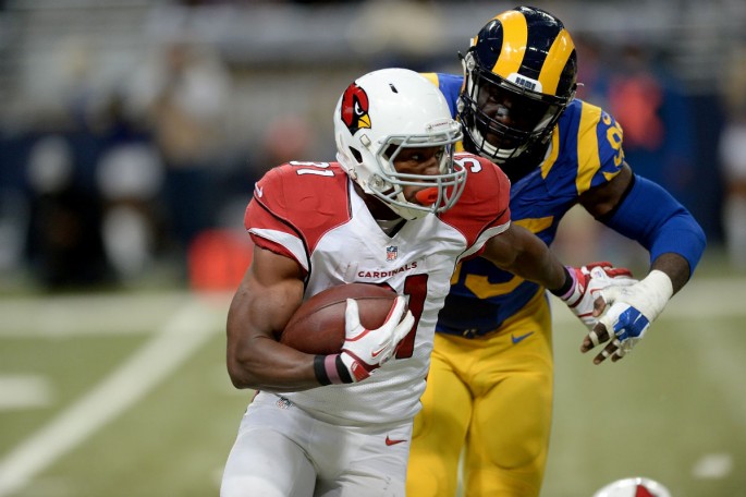 Arizona Cardinals running back David Johnson (#31) carries the ball while under pressure from St. Louis Rams' Aaron Donald.