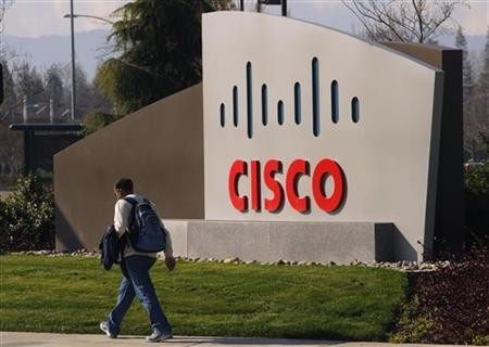 A pedestrian walks past the Cisco logo at the technology company's campus.
