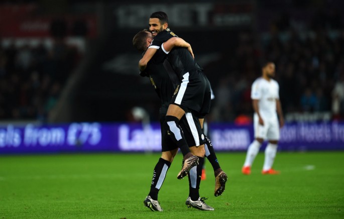 Leicester City winger Riyad Mahrez is lifted by teammate Danny Drinkwater after scoring a hat trick against Swansea City.