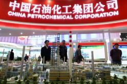 Chinese visitors look at a model of the China Petrochemical Corporation (Sinopec) at an expo in Beijing on March 21, 2009.
