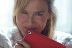 Renée Zellweger smiles while clutching an iPad.
